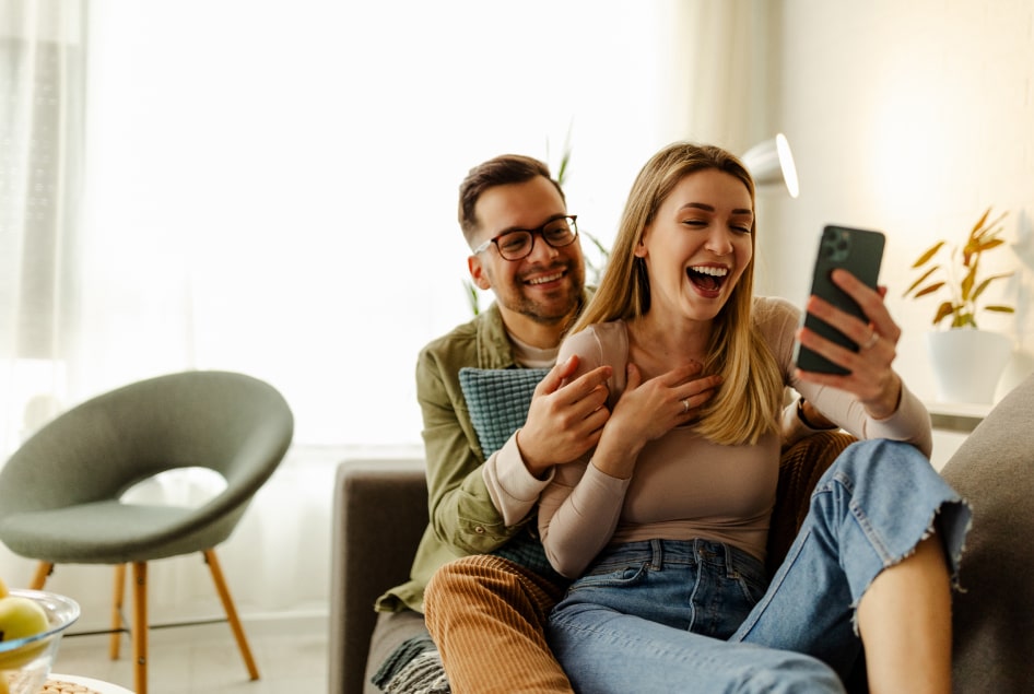 Couple relaxing at home and booking a dental appointment online